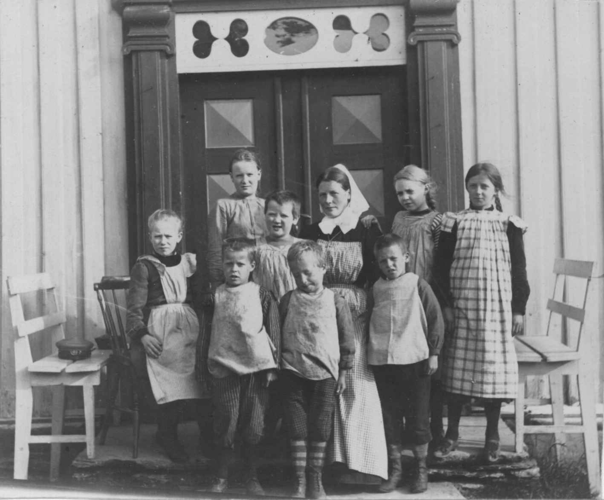 Feriekoloni på Suterøen. Barna og bestyrerinnen på trappa foran bygningen.