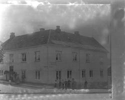 Avfotografering. Mennesker utenfor stort trehotell, Victoria