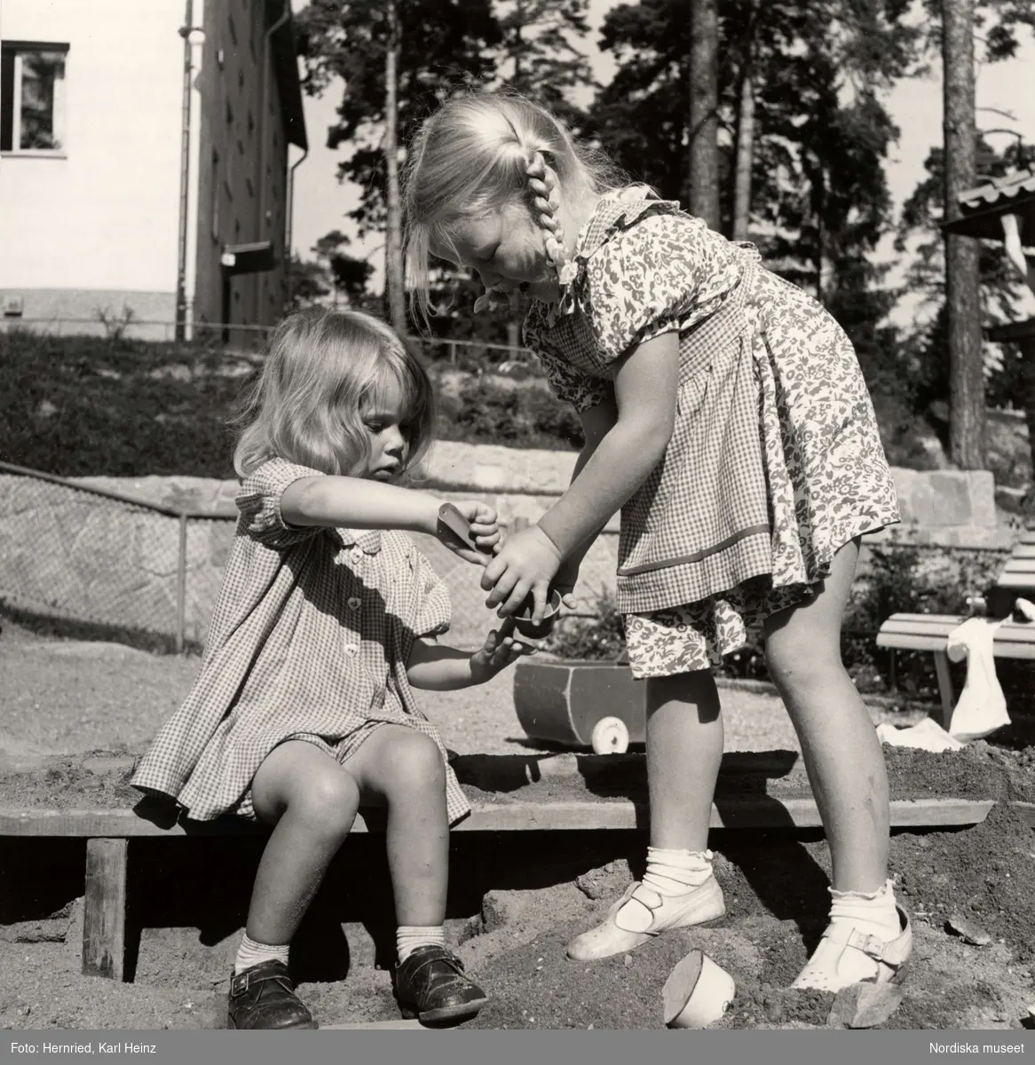 Två flickor leker i sandlåda