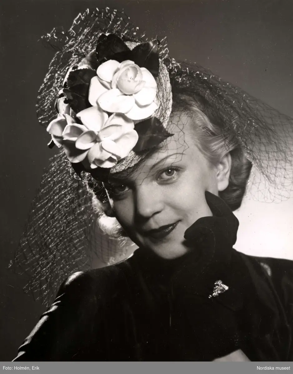 Hattmode, Nordiska Kompaniet 1941. Kvinnlig modell iförd liten rund hatt med flor och blomsterdekoration.