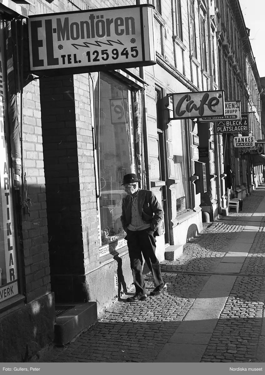 En man tittar i skyltfönster på en gata i Klarakvarteren, Stockholm