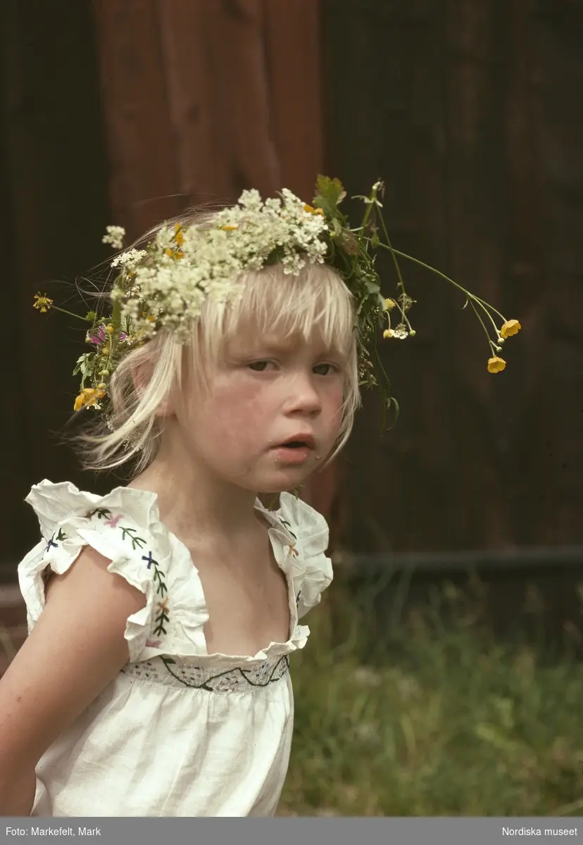 Midsommarafton. Väddö, Kista hembygdsgård. Liten flicka med blomsterkrans i håret.