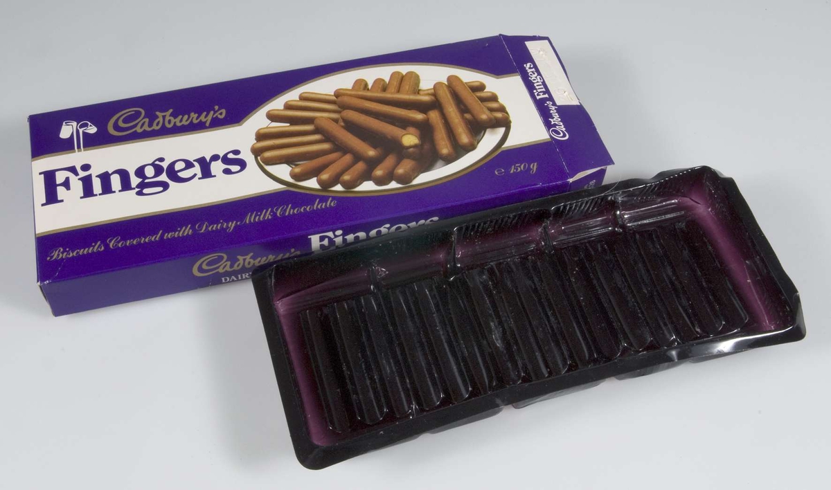 Pappförpackning för chokladkex i lila och vitt med text: Cadbury´s Fingers. Inuti förpackningen en mörklila plastask där kexen förvarats. På kortsidan märkt med bäst före datum 260590 W.