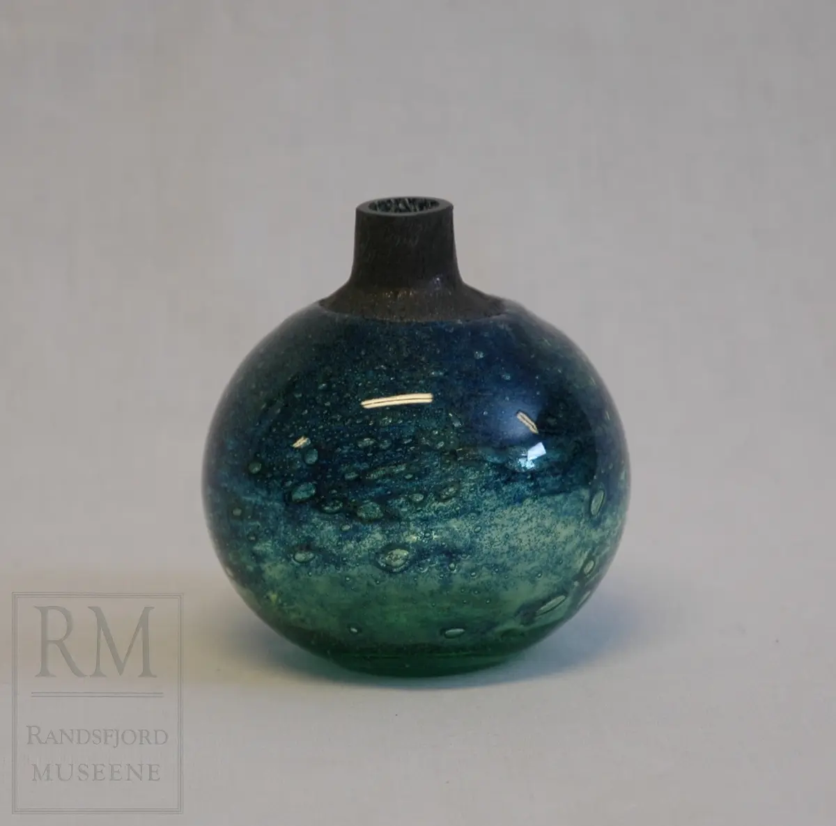 B: Emballasjen har motiv av en glassblåser på alle sider.