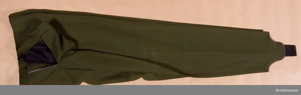 Skidbyxor m/1968. Tillverkad i grönt tyg, är avsmalnande nedåt och försedda med hålfothällor av resår, har två sidfickor och två bakfickor samt hällor för bälte.