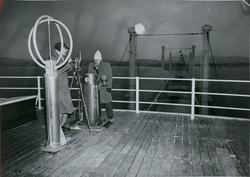 To menn kalibrerer kompass under prøvetur med tørrlasteskipe