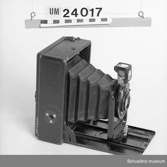 Kamera med sammanhörande utrustning UM024016 - UM024019. Märket Ernemann. Läderbälg med text på objektivet: "Ernemann Doppel-Objektiv  1:11 f.= 14 cm. 511618".