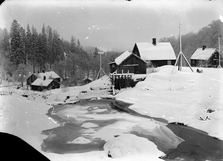 Enligt fotografens noteringar: "Gamla Smedbruket Munkedal omkr. 1914 - fotograf S. Sahlberg. Gammal stuga till vänster den...Mycket gammal stuga."