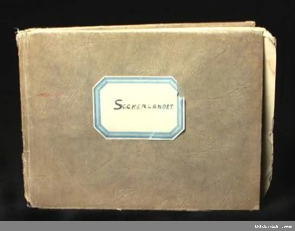 En sångbok av fröken Malin Sundelin, Sthlm, 1933. 24 sidor. Brunt pappersomslag med etikett på märkt: SOCKERLANDET.Lagad med tejp.