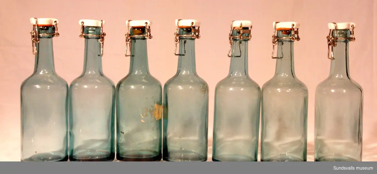SuM 4963:1-7 sju stycken flaskor i gröntonat glas med patentkork. Flaskorna är tillverkade hos Årnäs.