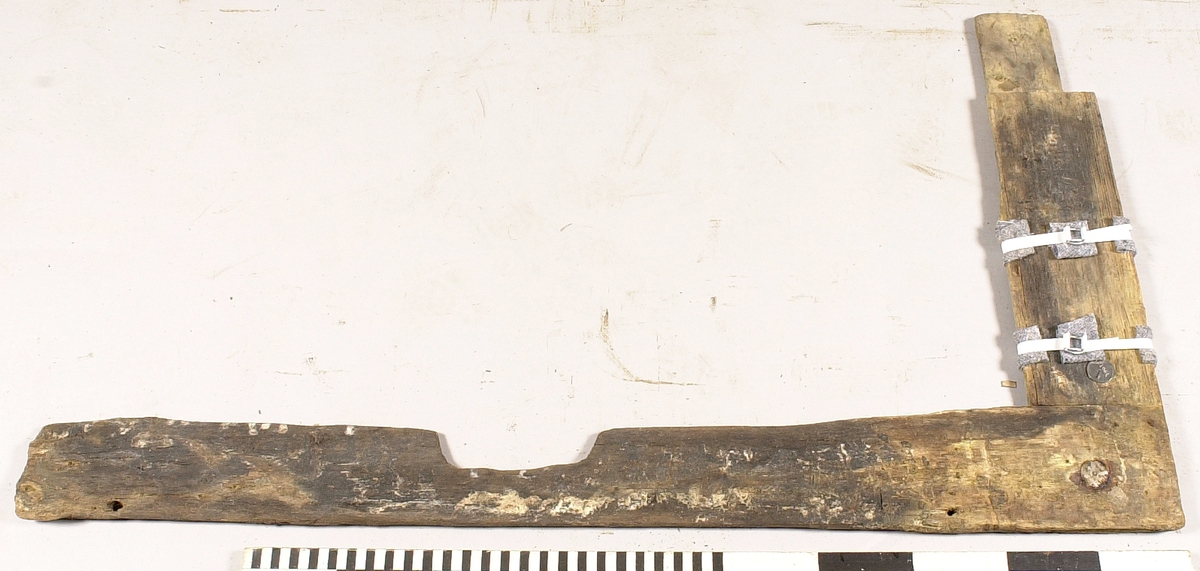 Ram till panel.
Urtag mitt på. Två genomgående spikhål på ytterkanten. Ena änden sitter ihop med fyndnummer 19612 med två kvarsittande träbultar.