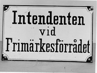 Skylt i emaljerad järnplåt, rektangulär med text enligt MRK
isvart mot vit bottenfärg. Längs skyltens kant en svart rand
indrageni hörnen. I hörnen finns hål för fastsättning av skylten.
Skyltenanvänd på Frimärksförrådet i Stockholm.