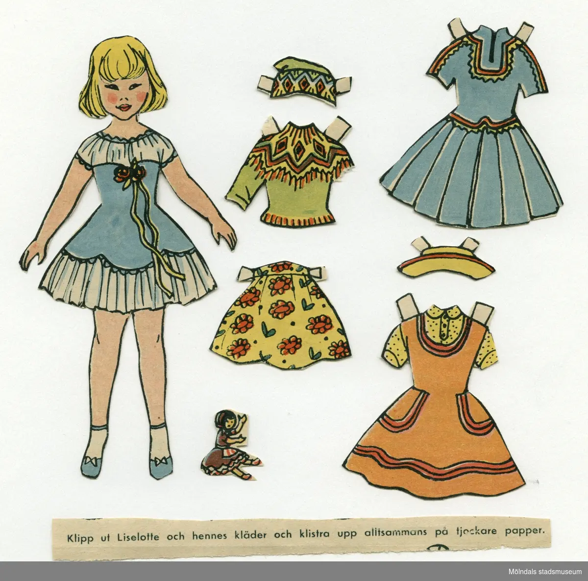 Pappersdocka med kläder och tillbehör, urklippta ur tidning på 1950-talet. Dockan föreställer flicka med blont hår, iklädd blå och vit klänning, strumpor och skor. Garderoben består av en klänning, en sameklänning, kjol, hatt,  samt tröja med matchande mössa.Som tillbehör har pappersdockan en egen docka. I materialet finns också ett urklipp med texten: "Klipp ut Liselotte och hennes kläder och klistra upp alltsammans på tjockare papper".Dockan förvaras i ett litet kuvert med tryckt text: "Lycko-brev".