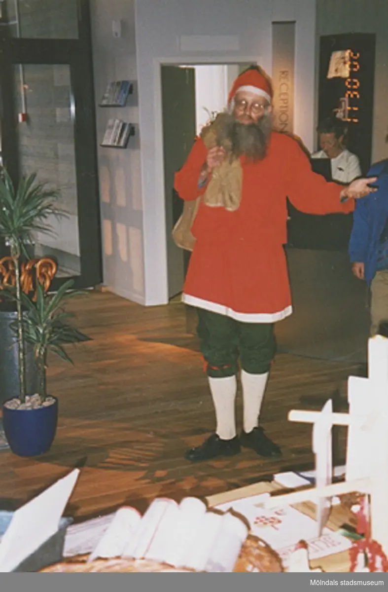 Invigningen på Mölndals museum 2002-11-30.
Lars Gahrn, utklädd till tomte, välkomnar i huvudentrén. Pia Persson ses i bakgrunden.
Tomteutställningen: 30/11-02 - 1/1-03.