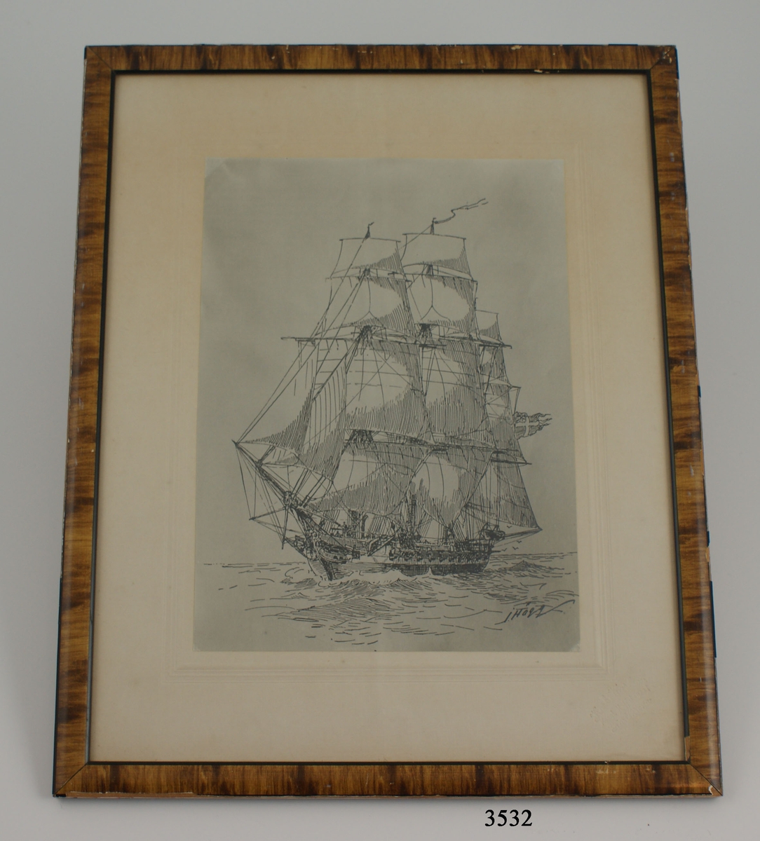 Fotografi, inom glas och ram, av korvetten Carlskrona under segel, efter en tavla av amiral Hägg.