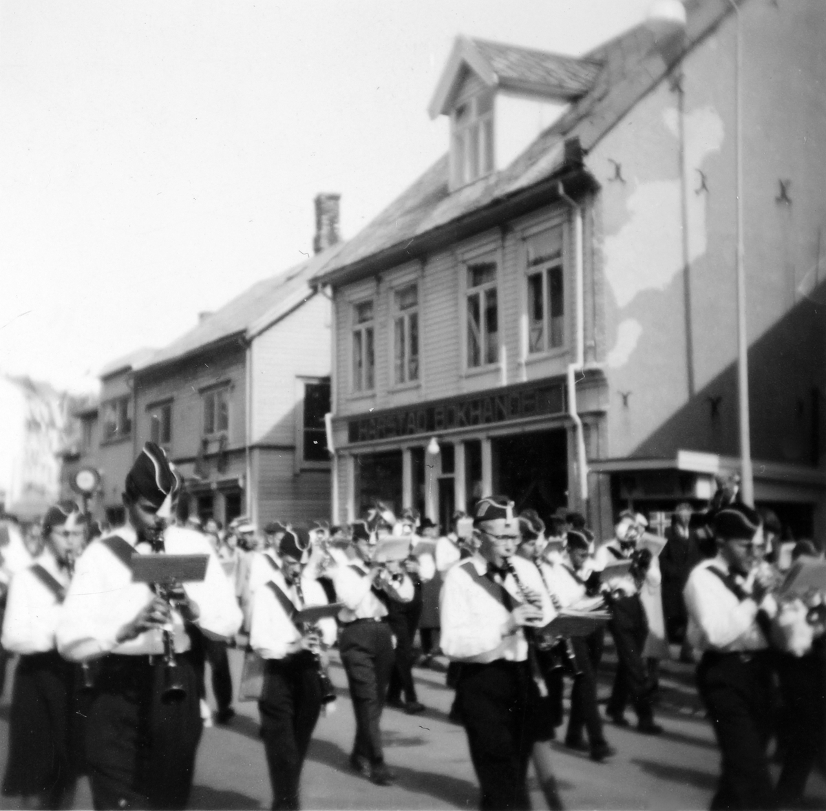 Skolekorps i Strandgata på 17. mai. I bakgrunnen Harstad Bokhandel.