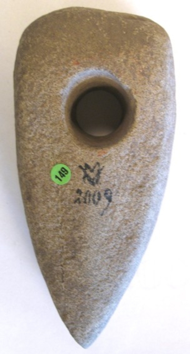 02 009: Funnen på Vänersnäs, Västergötland.  Köpt 1907-10-10 av G.M. Blomqvist för 1,50:-
 

Skafthålsyxa, grovt bultad och oslipad rektangulär genomskärning och med koniskt skafthål. Bred i det närmaste rak nacke. L. 14,3 cm. B. 6,5 cm. Tj. 4,5 cm.