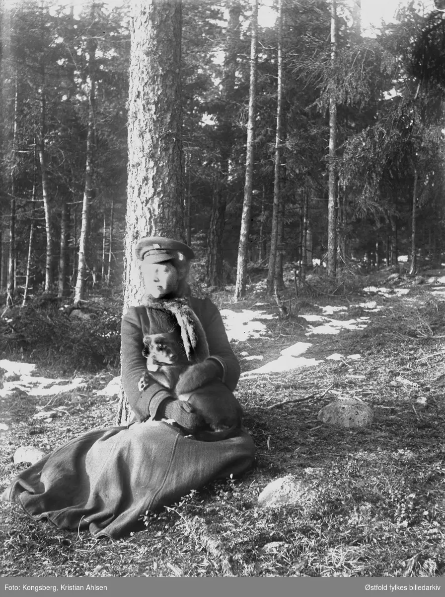 Her sitter Ragna Kongsberg med hunden Dolly på fanget, en søndag i april 1907.