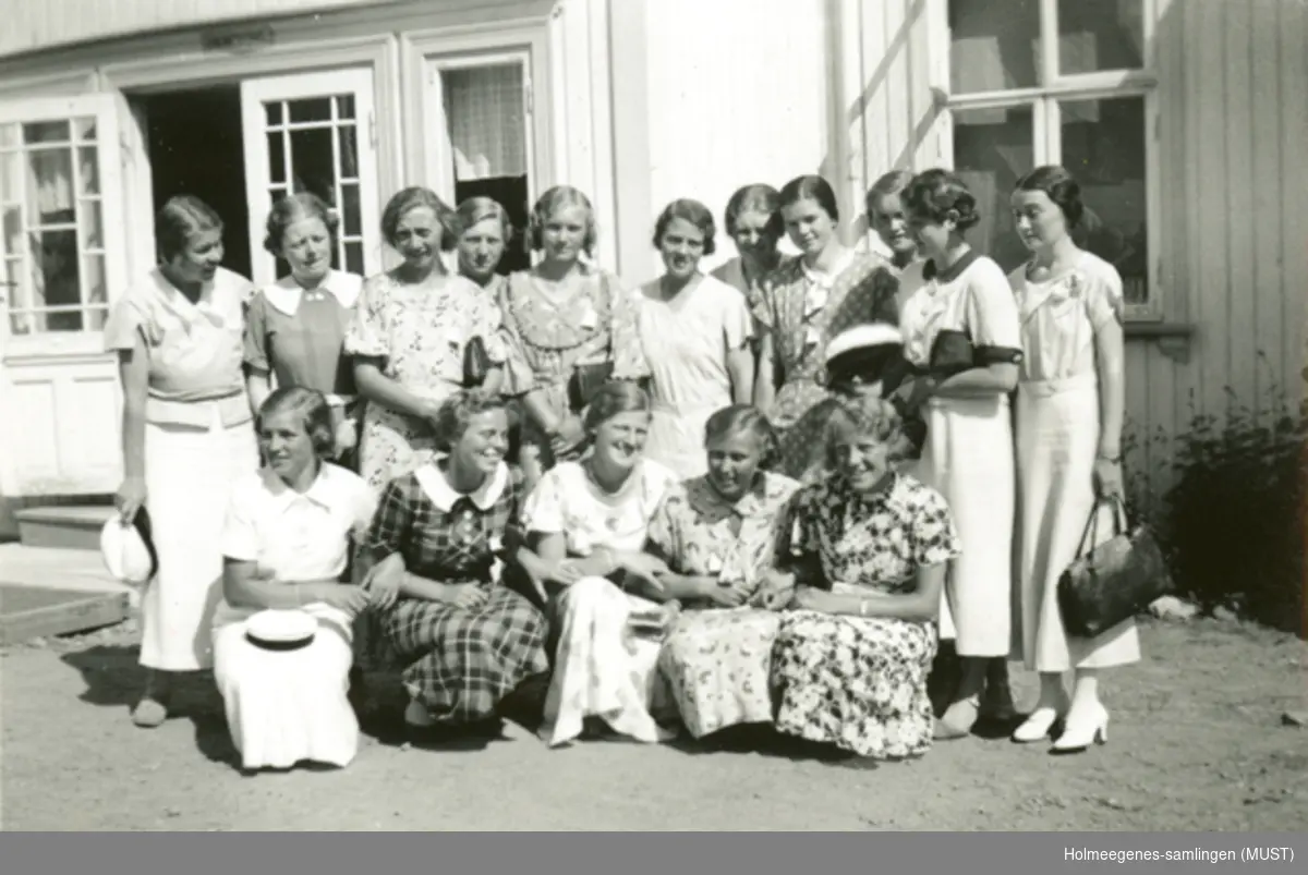 En gruppe kvinner foran en bygning. Noen har russeluer i hånda. "Viken juli 1935".