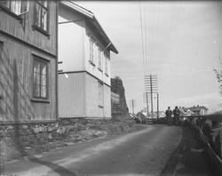 To personer og hus langs Tangeveien i Kragerø