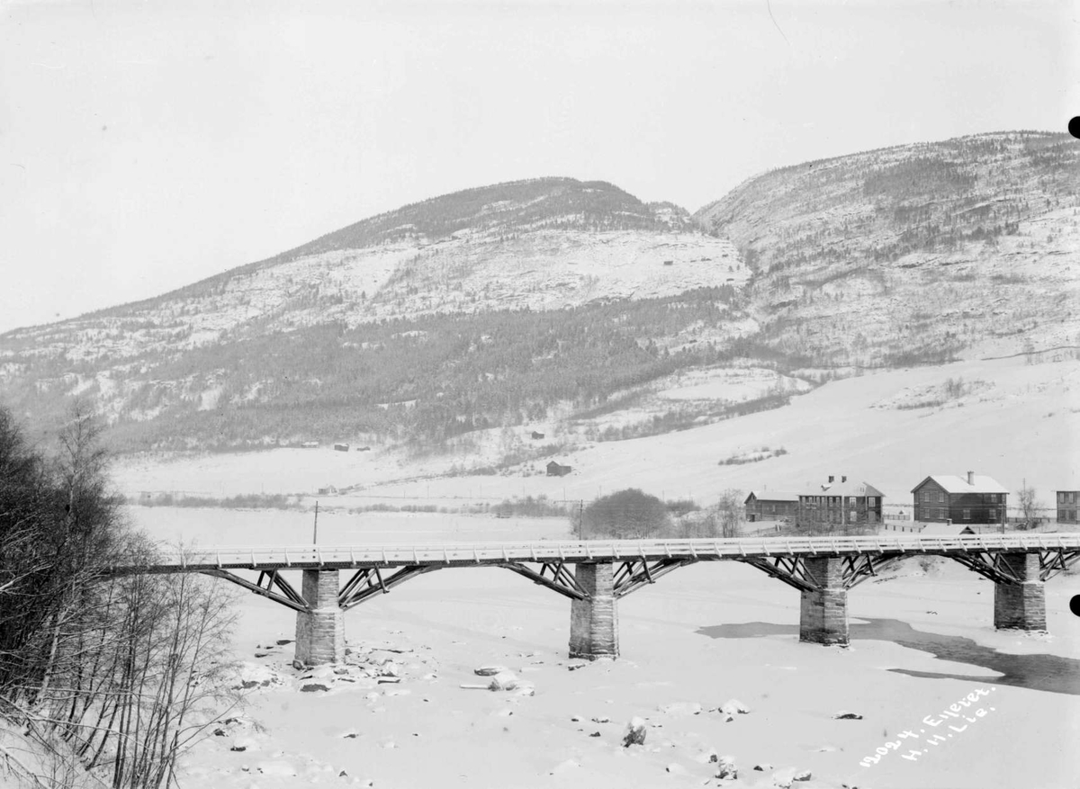 17.01.1909. Nord-Fron. Vinterparti ved Sundbroen og N. Byhre. Islagt elv, bro, bolighus, uthus, fjellformasjoner.
