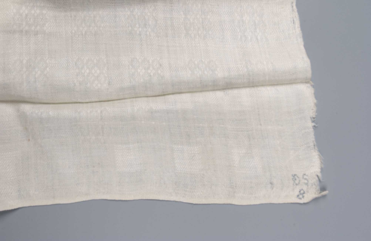 Mønstervevd bordduk i lin, liten fald maskinsydd i begge kortender.
