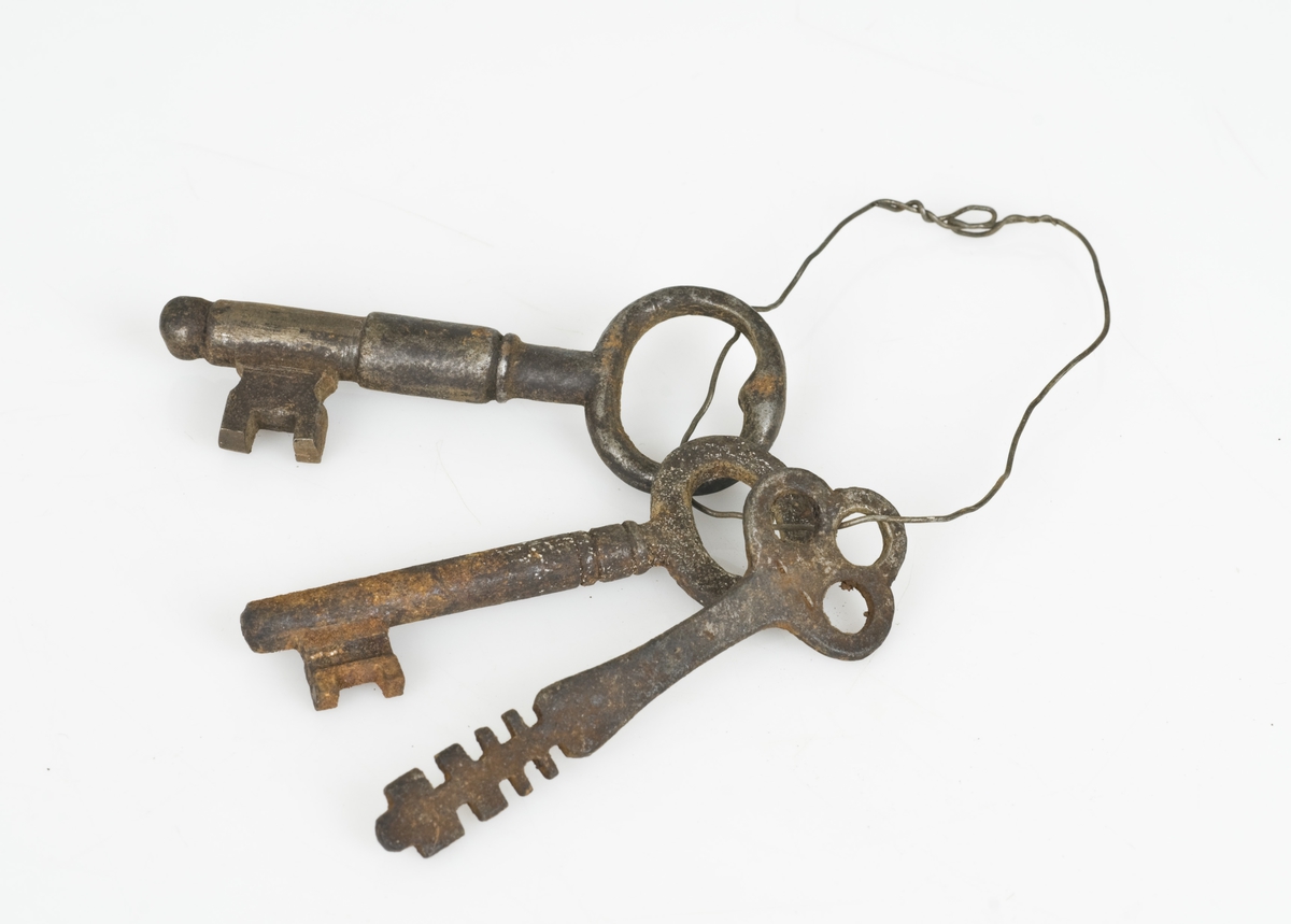 3 nøkler av jern.
Nøklene henger sammen i en stålring.
