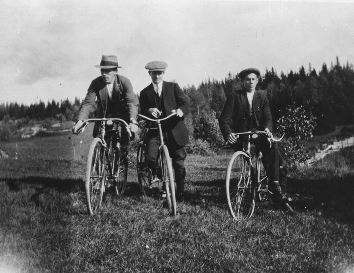 Gruppebilde. Tre menn på sykler.