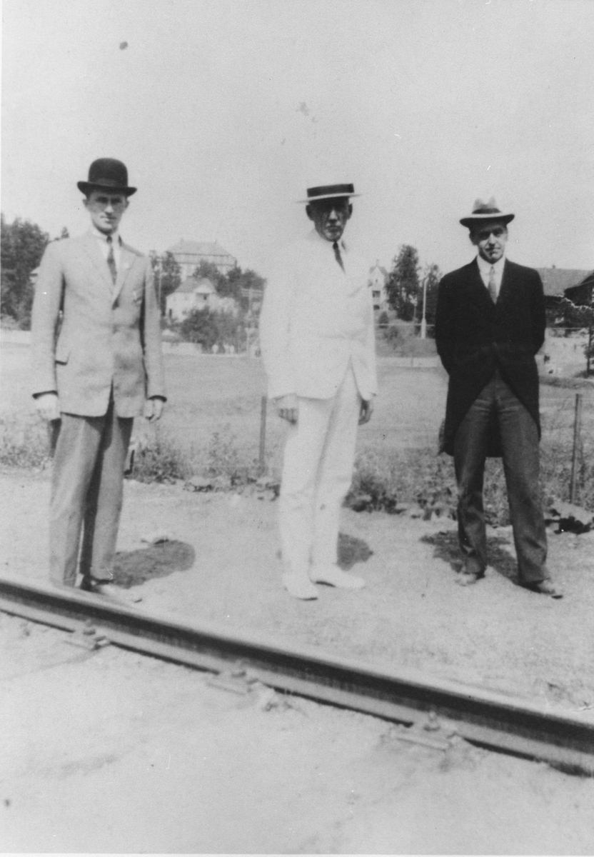 3 menn i dress og hatt ved Kolbotn stasjon i anledning av K.I.K.'s 10-års jubileum.
