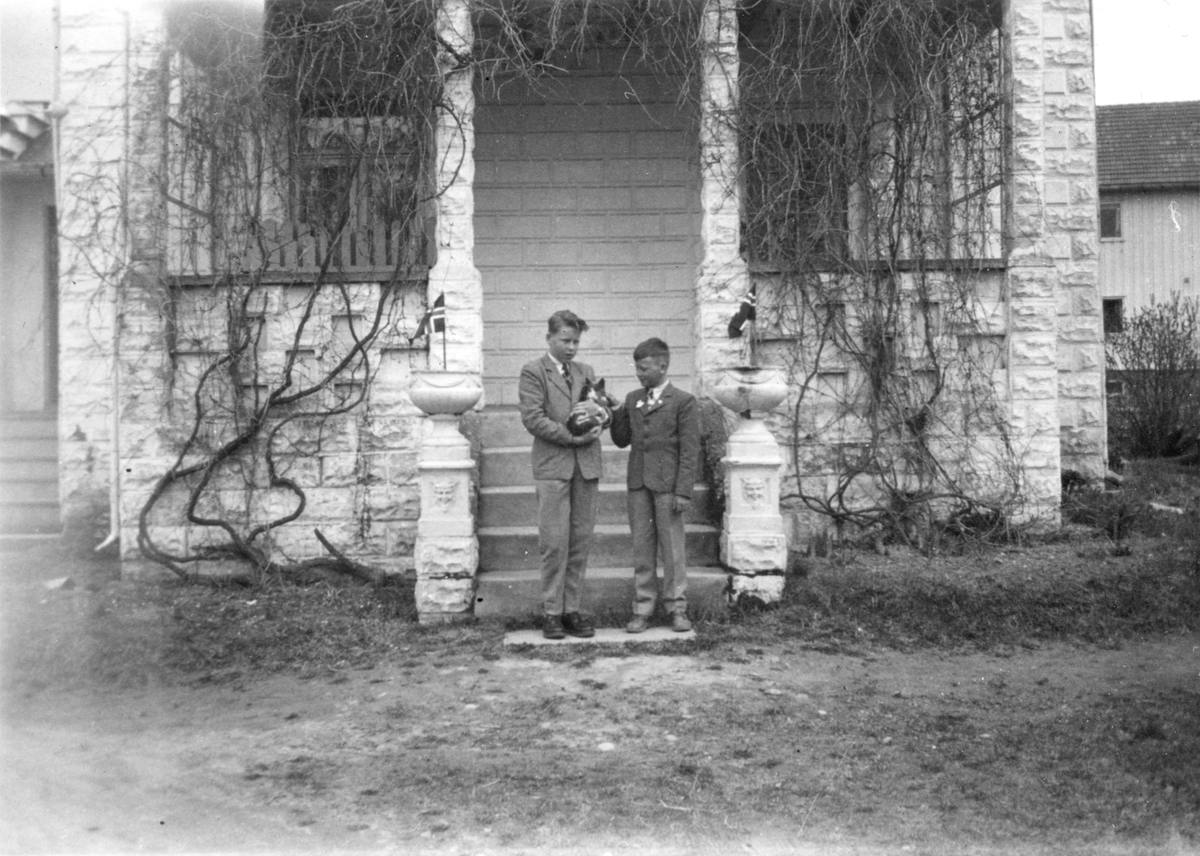 Egil Bingen og Steinar Bingen med katt fotografert foran trapp ved terasse 17 mai 1955.
