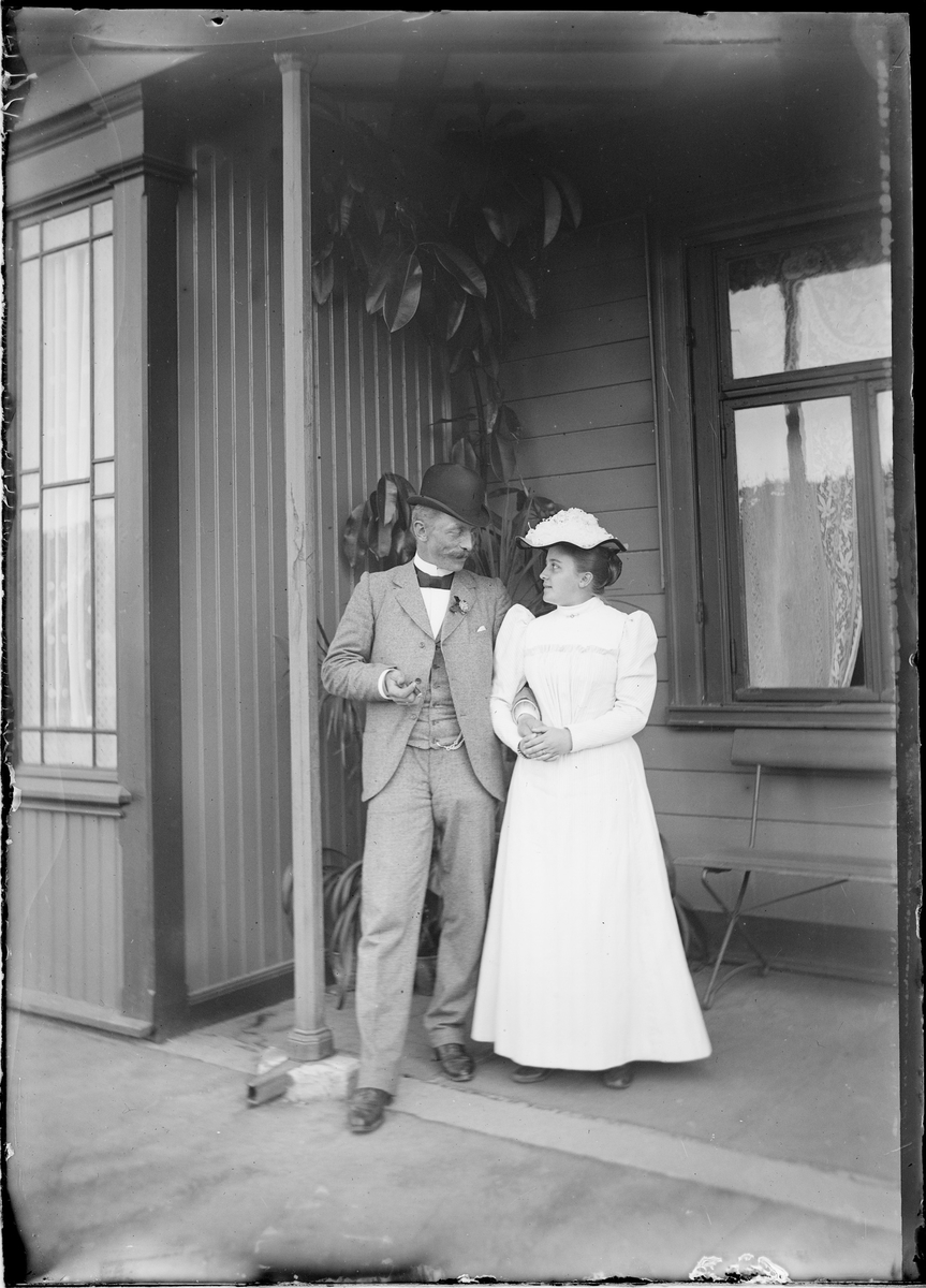 Jens og Elise Frölich (f. Mathiesen) foran en husvegg.