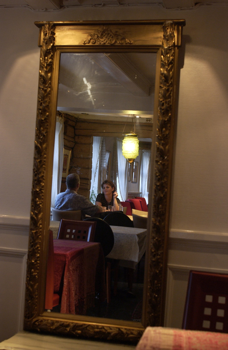 Speilbilde. Mann og kvinne med sigaretter ved et bord, Jungeltelegrafen, Drøbak.