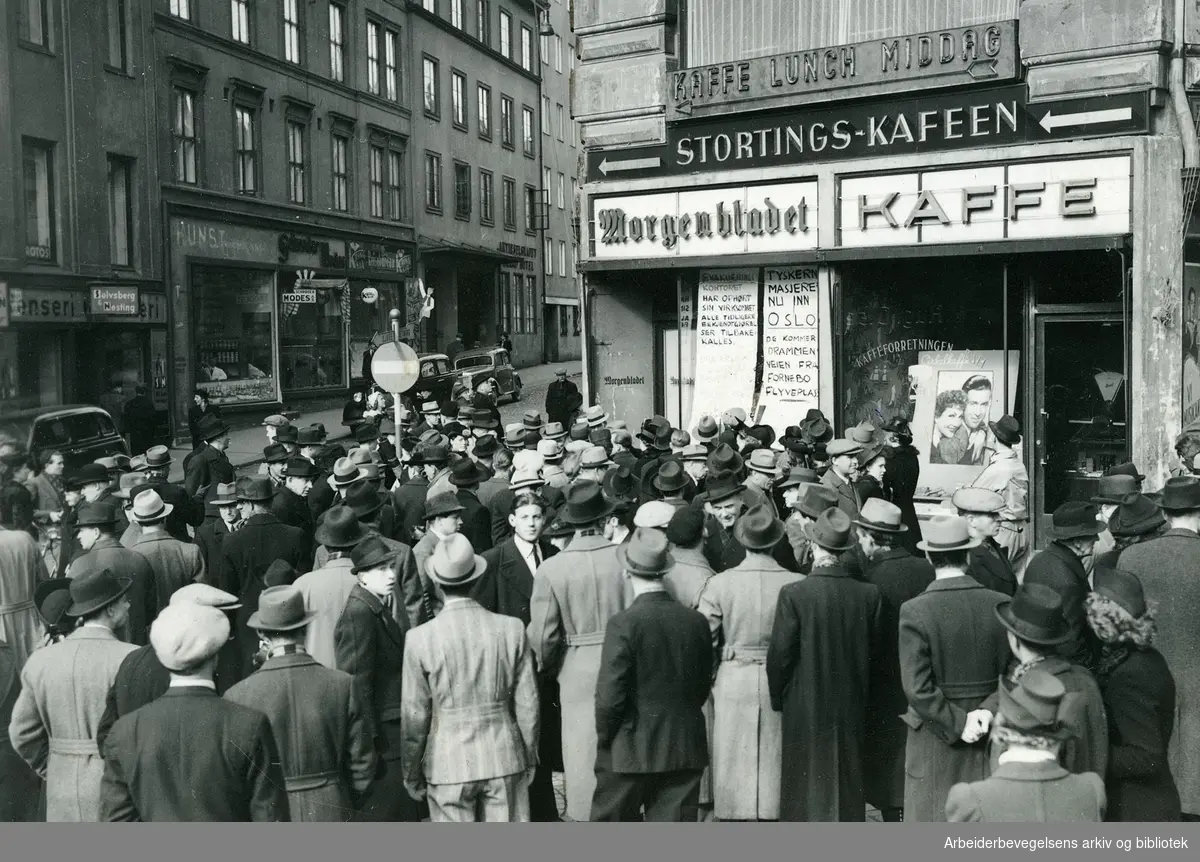Morgenen den 9. april 1940 utenfor Morgenbladets ekspedisjon nederst i Lille Grensen. På en plakat i vinduet står det: "Tyskerne masjerer nu inn i Oslo. De kommer Drammensveien fra Fornebo flyveplass." Ved siden av: " Evakueringskontoret har ophørt sin virksomhet. Alle tidligere bekjentgjørelser tilbakekalles."