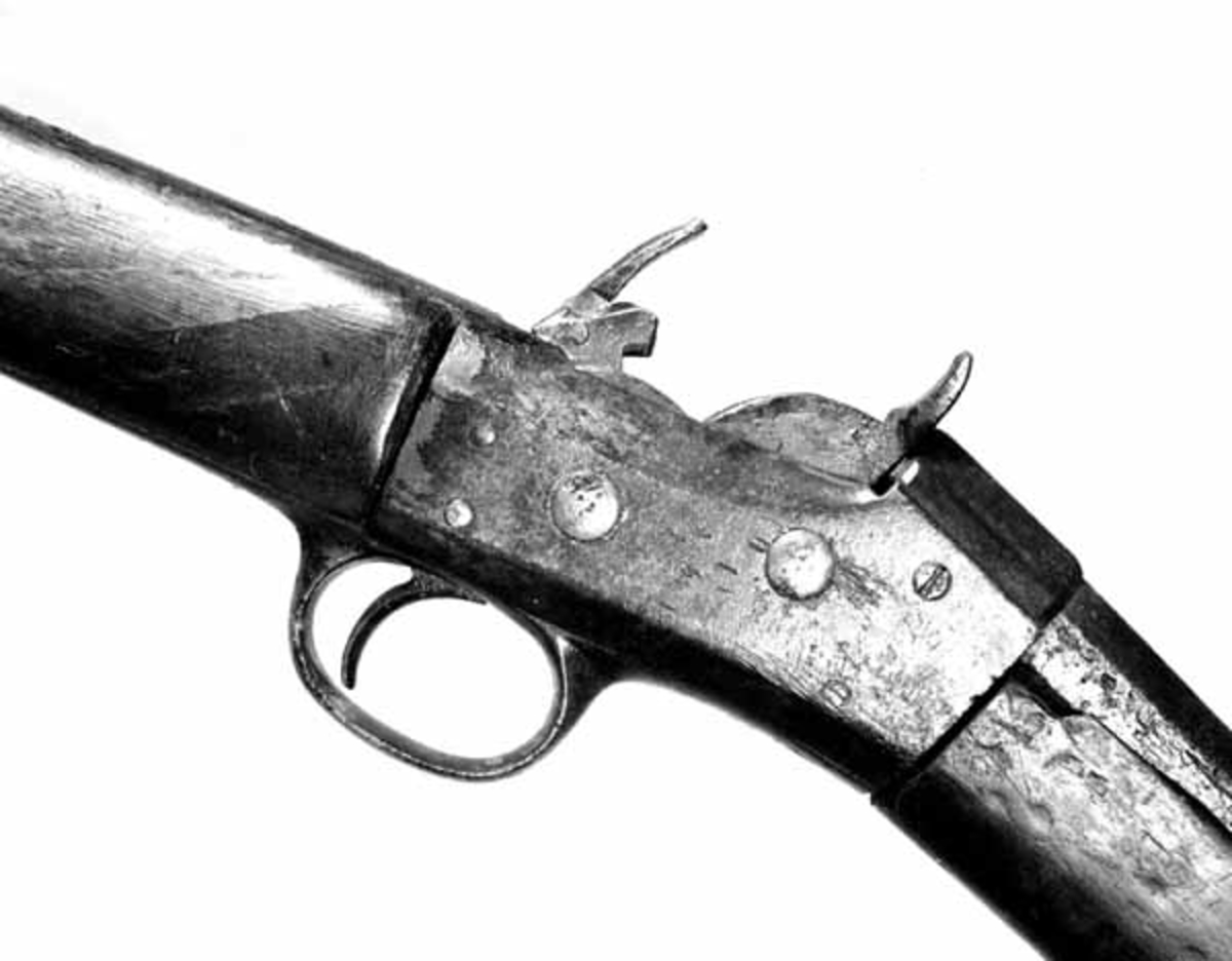 Dette er et glattboret Remingtongevær. Kolben er ikke original. Den nøyaktige tilpasningen viser dette. Dessuten er det på enden av den satt på et ekstra stykke, 3, 5 cm langt. Remingtons system ble konstruert av en urmaker Geiger og patentert i 1863. Remington & Sons våpenfabrikk kjøpte patentet av han. I 1867 kom så den første Remingtonrifle til Norge. 
Privat tilvirket Remington. 
