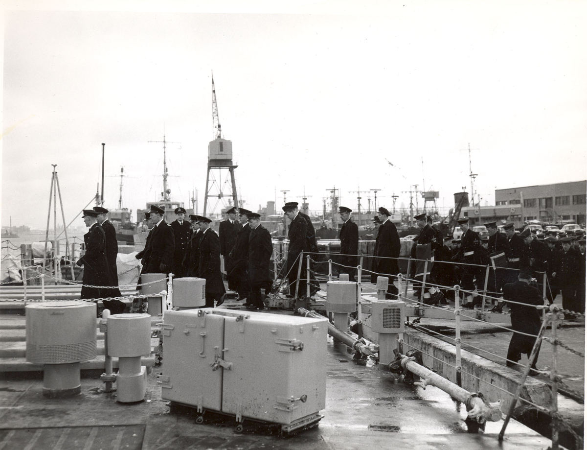 Overtakelsen av River-kl.fregatt KNM "Draug", ex. HMCS Pentang 25. januar 1956. Det norske mannskapet marsjerer om bord i KNM "Draug" før kommandoen heises.