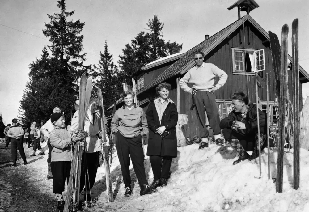 Budor turisthytte med folk på ski utenfor.