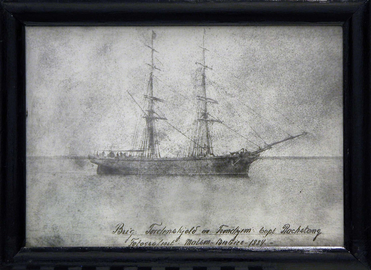 Det første skoleskip briggen "Tordenskjold" liggende med seilene loret ved en kyst eller i en fjord 1884.