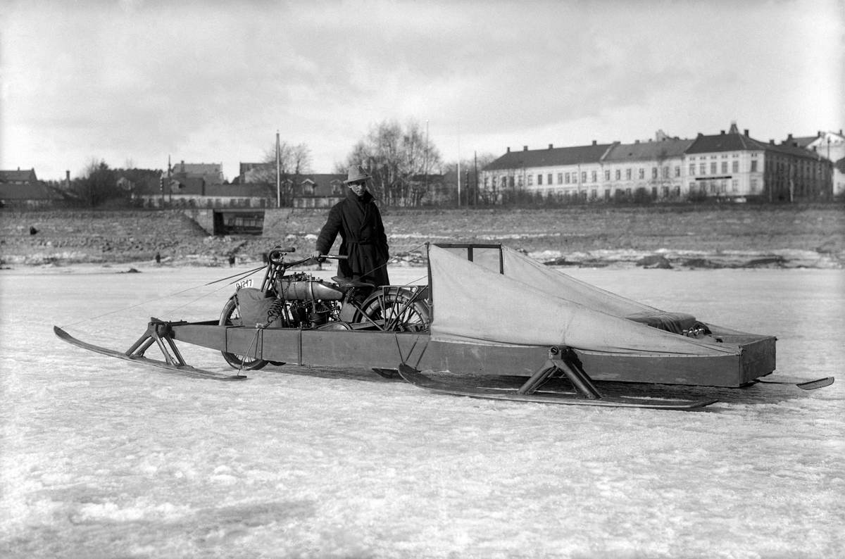 Ingeniør Sverre Hagen med sitt transportkjøretøy for kjøring på dårlig is som han brukte til å frakte passasjerer mellom Hamar, Nes, Helgøya og Gjøvik. 1925. Harley Davidson fra ca 1919-24 som har fått en skikkelig tung jobb. Harley forandret seg lite i disse årene hva utseendet gjelder. Frem til 1921 var det kun 1000ccm, etter 1921 kunne man også få 1200ccm.