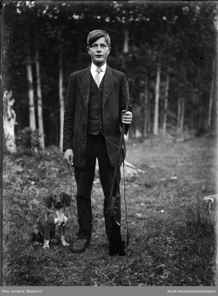 Mann på jakt i dress og slips med hund.