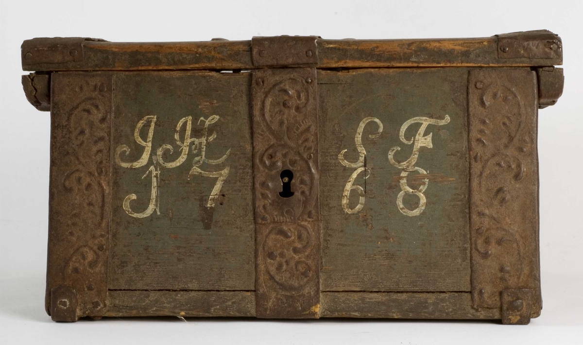 Ferdaskrin i tre med brede jernbeslag i dreven dekor.