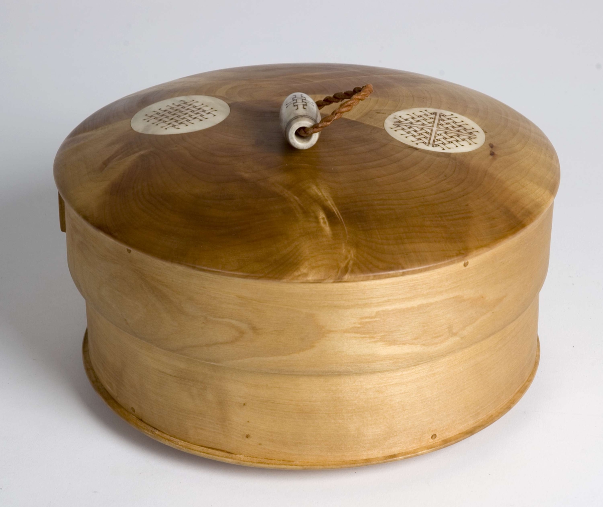 Smykkeskrin (søljeskrin) med lokk, sirkelrundt, sveipet, av bjørk, på lokket knapp og to dekorfelt av reinhorn med flettverksdekor.