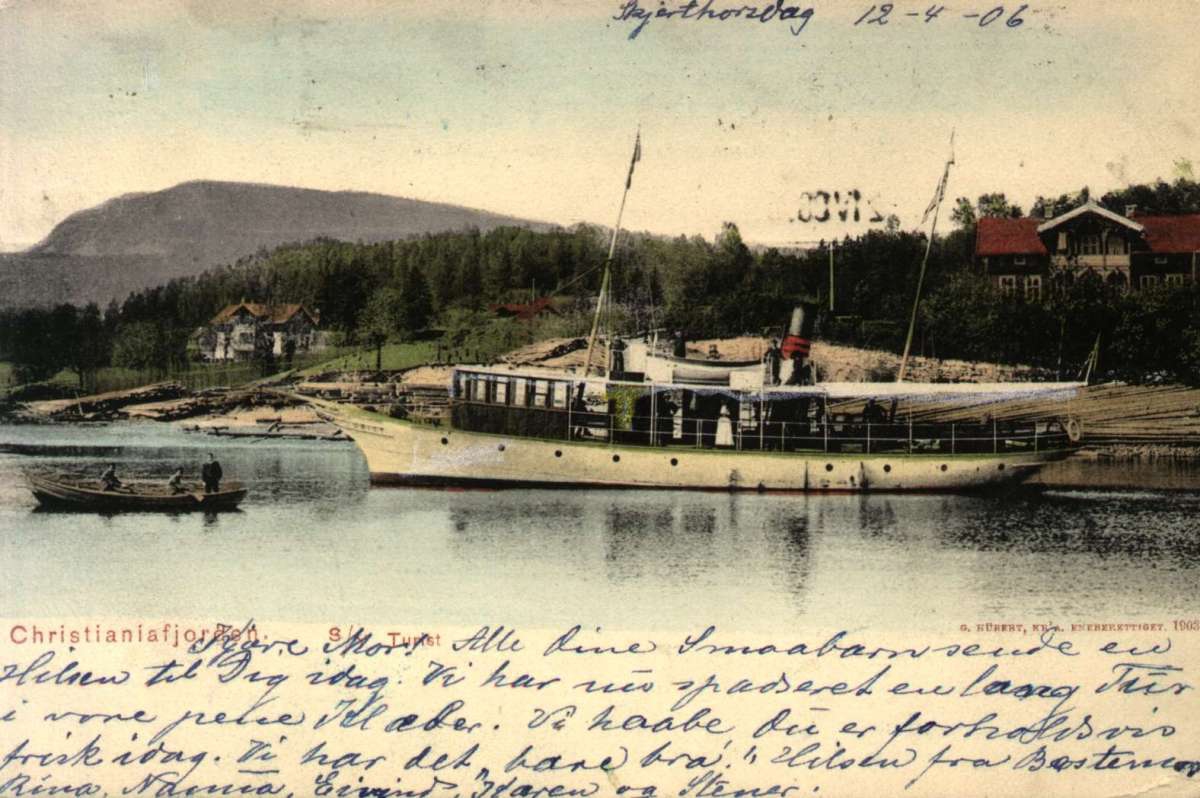 Postkort. Kolorert. Passasjerfergen "S/Y Tourist" ligger til kai i Christianiafjorden (Oslofjorden), en ro båt ligger ved siden av. Stemplet 12.04.1906.